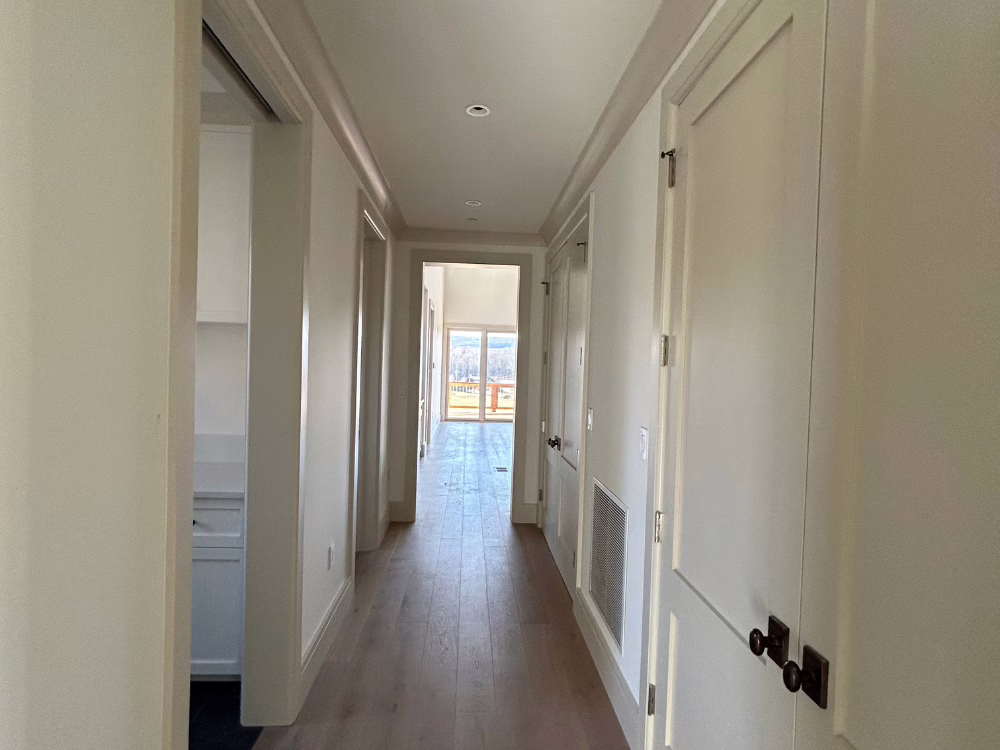 Bright residential hallway after professional interior painting with neutral tones and smooth finish