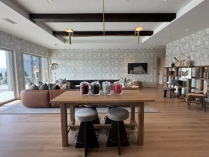 Open living space with dining table, shelving, and interior painting and wallpaper.