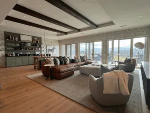 Living room with beams, large windows, and interior painting and wallpaper details.