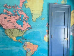 Wallpaper map installation with blue painted door and trims