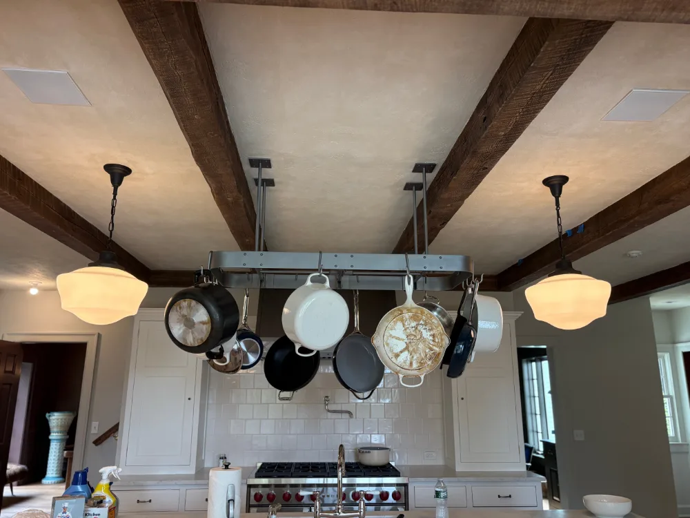 Interior paint restoration highlighting kitchen beams and hanging cookware.