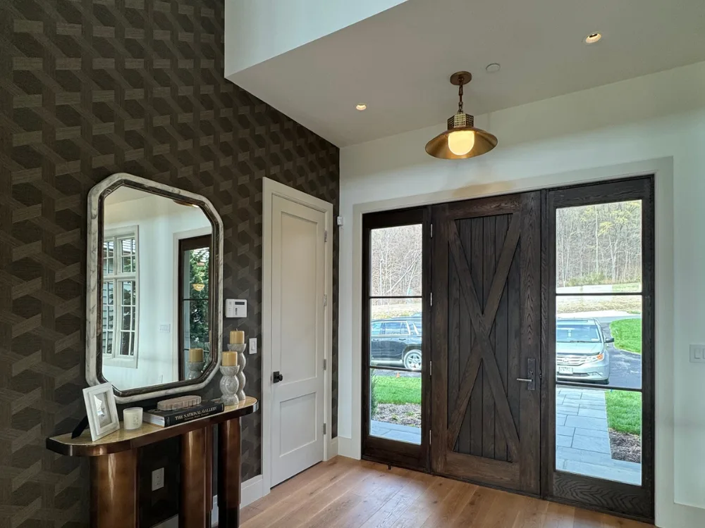 Modern entryway with wallpaper painting installation and wooden door.