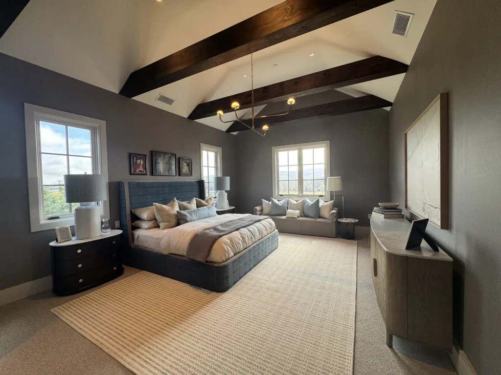 Interior bedroom painting with neutral wall colors, vaulted ceiling, exposed beams, and cohesive finish