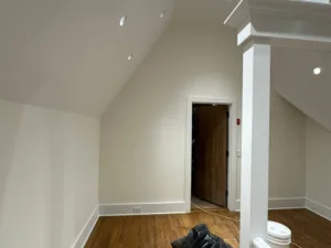 Interior painting restoration showing finished walls, doorway, and trim details.