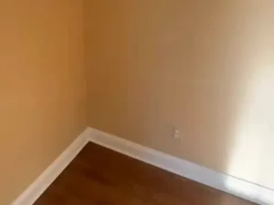 Interior wall painting showing finished corner, baseboard, and smooth wall surface with clean lines