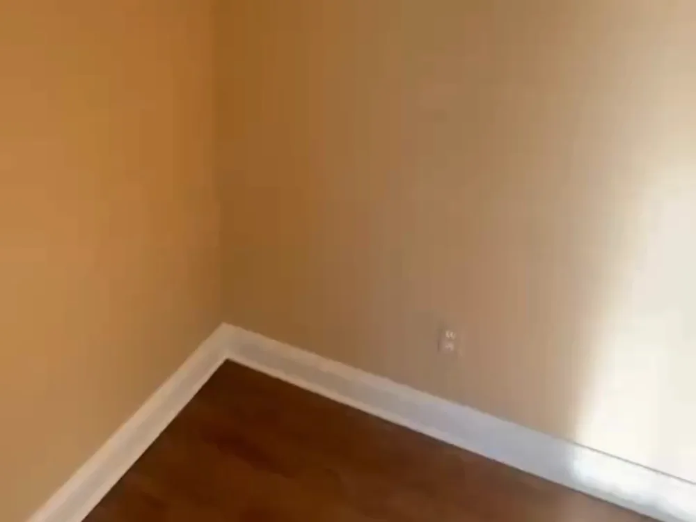 Interior wall painting showing finished corner, baseboard, and smooth wall surface with clean lines